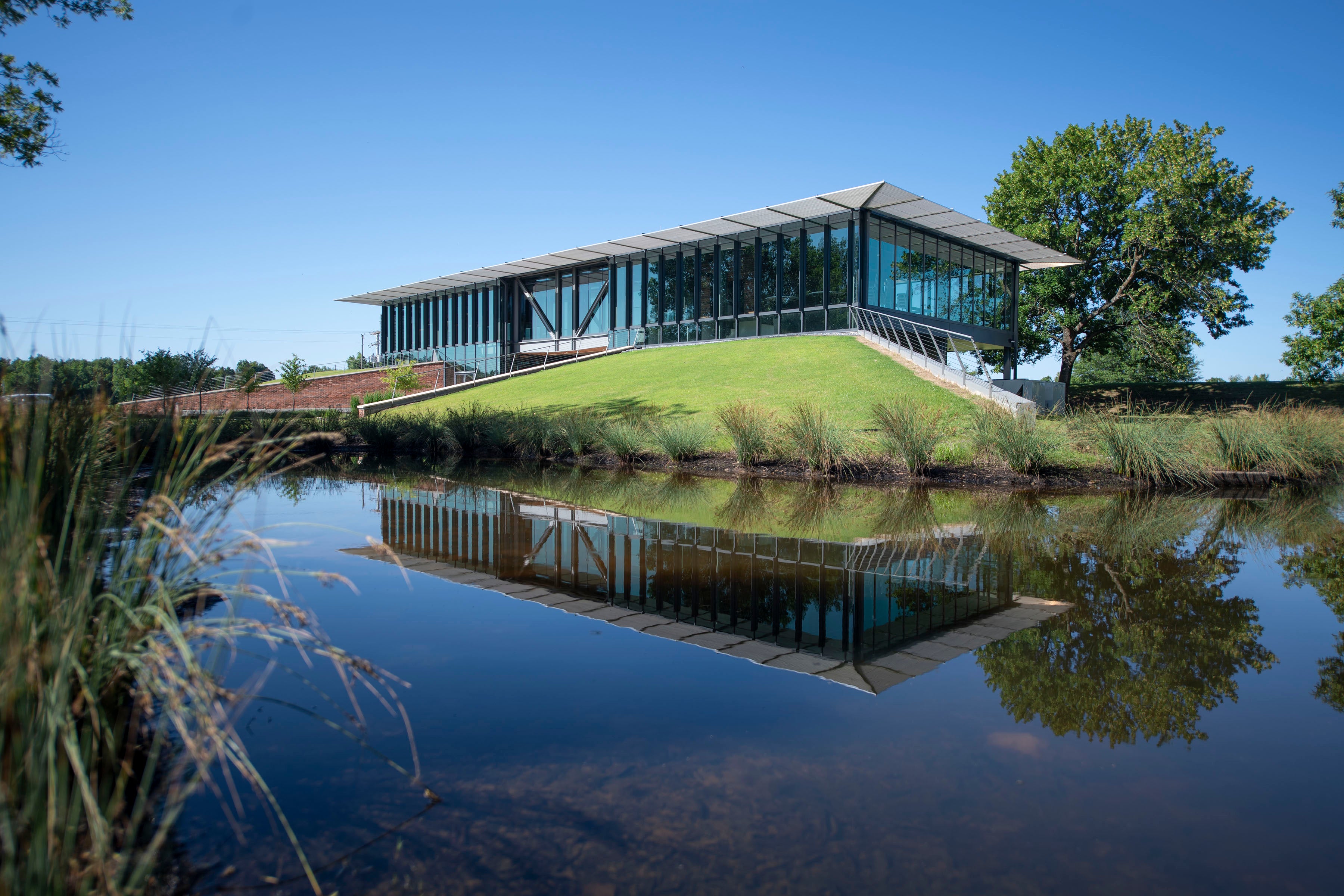  new visitor center, completed in 2019, facing the White River. A full reflection of the building appears in the water at foreground of image